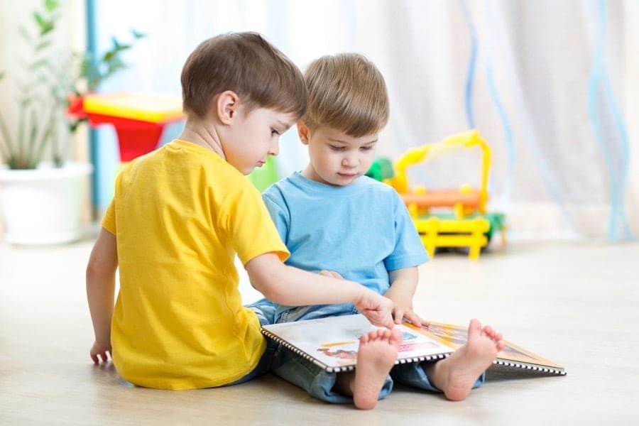 Children learning to read together using phonics by blending letter sounds in an early reading activity